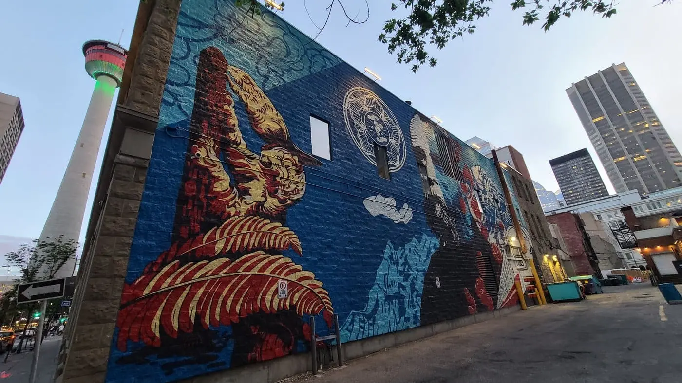 A colourful mural in downtown Calgary with the Calgary Tower in the background
