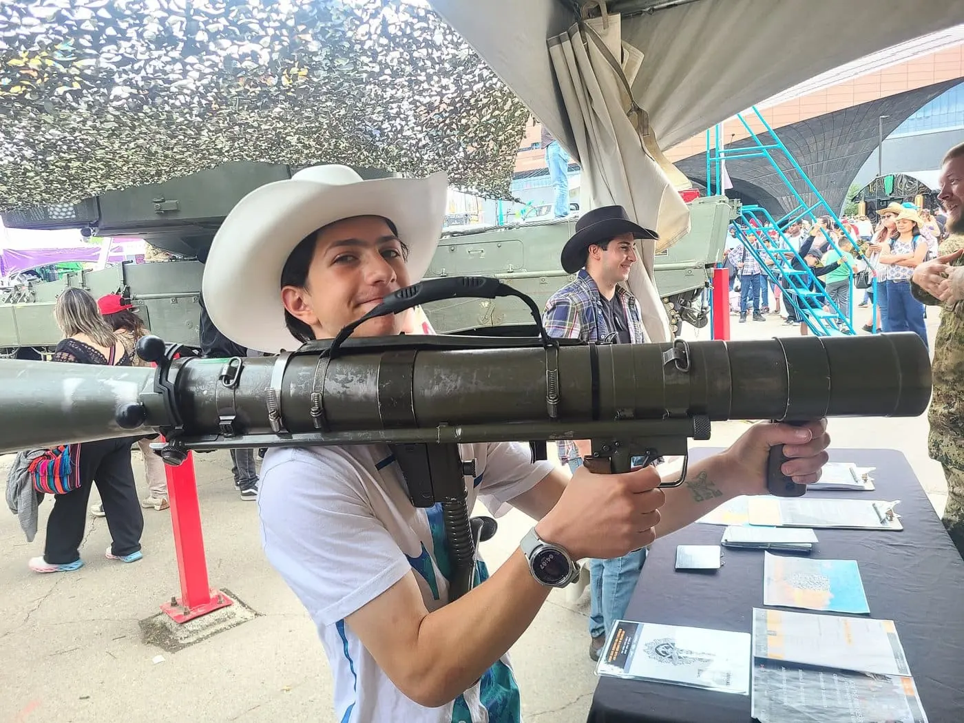 Simon Maxam at the Calgary Stampede holding a novelty item, midway lights behind him